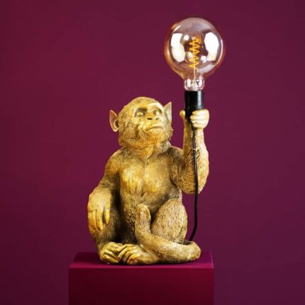 Gold Monkey Abu Table Lamp — sculptural gold animal lamp with a primate figure holding an Edison filament bulb, metal art sculpture and deco art lamp for modern living rooms