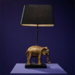 Elmo Elephant Lamp Gold-Black — sculptural elephant lamp with a detailed elephant figure base in gold finish and a black fabric shade, shown on a neutral surface as a decorative art sculpture for living room or entryway styling.
