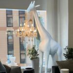 Giraffe Floor Lamp with chandelier lighting in a modern living room – handcrafted animal sculpture by Lume Art Gallery
