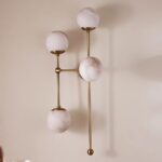 ARMSTRONG FOUR-LIGHT BRASS AND GLASS WALL SCONCE