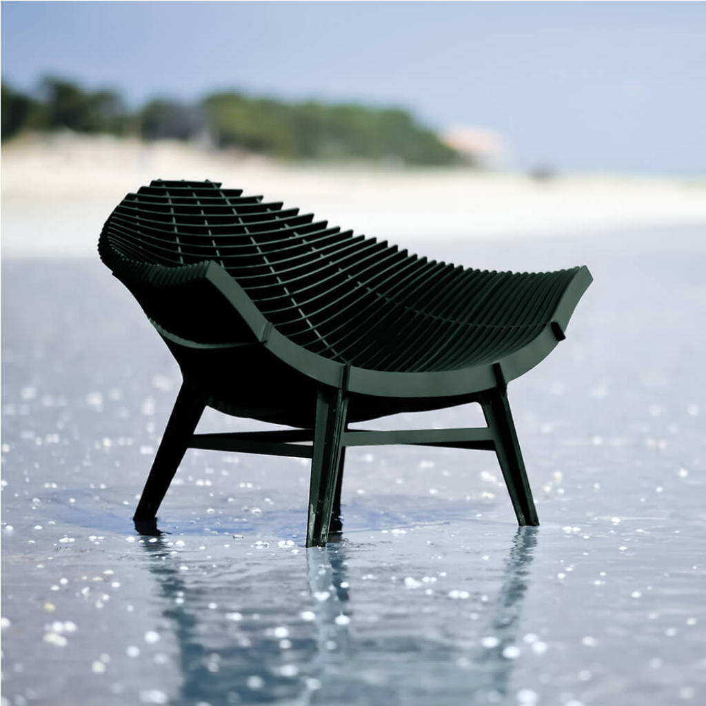 GREEN ARMCHAIR BY RACHEL & BENOIT CONVERS — wide seat formed from closely spaced parallel horizontal slats in deep green, on four angled cross-braced legs, on white background GREEN ARMCHAIR BY RACHEL & BENOIT CONVERS — wide seat formed from closely spaced parallel horizontal slats in deep green, on four angled cross-braced legs, on white background