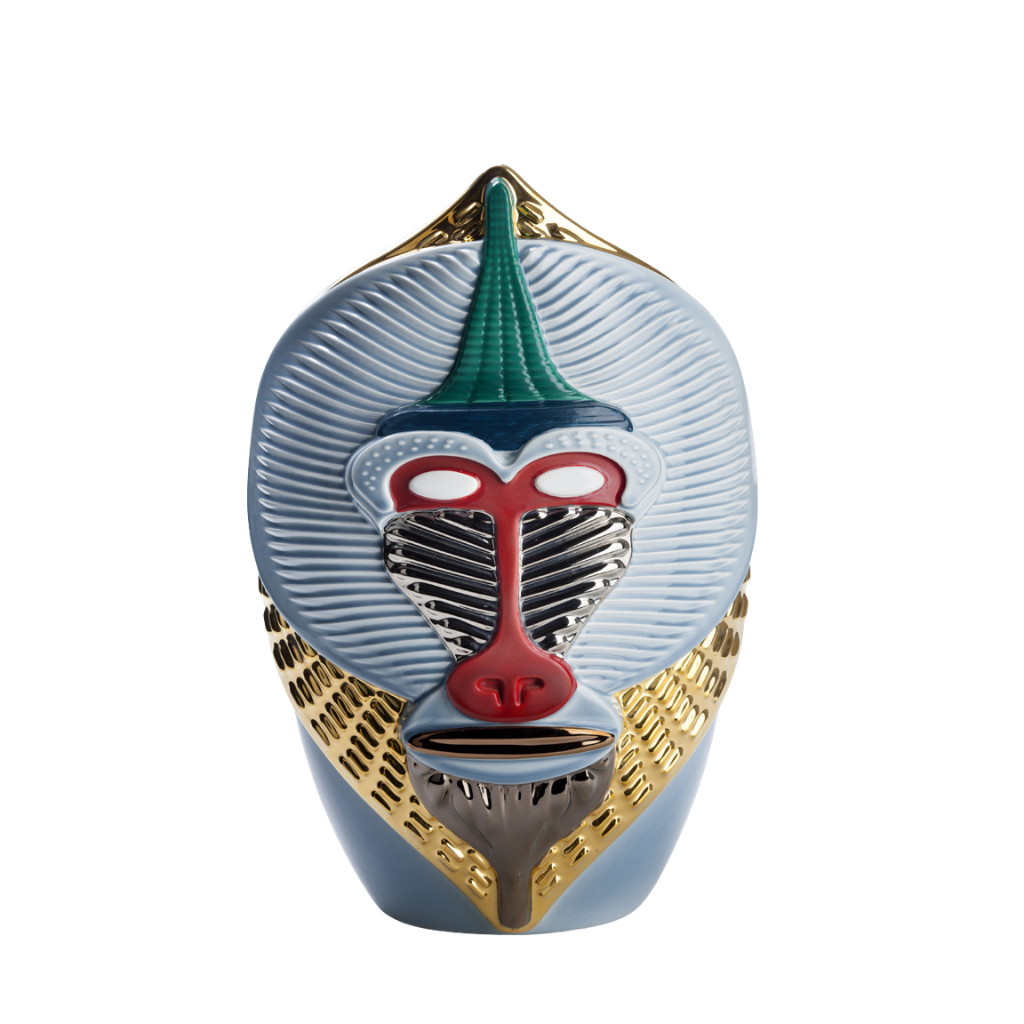 PRIMATES MANDRILLUS BY ELENA SALMISTRARO — sky blue ribbed ceramic mandrill vase with vivid red nose, silver muzzle, green crest, and gold collar detail. PRIMATES MANDRILLUS BY ELENA SALMISTRARO — sky blue ribbed ceramic mandrill vase with vivid red nose, silver muzzle, green crest, and gold collar detail.