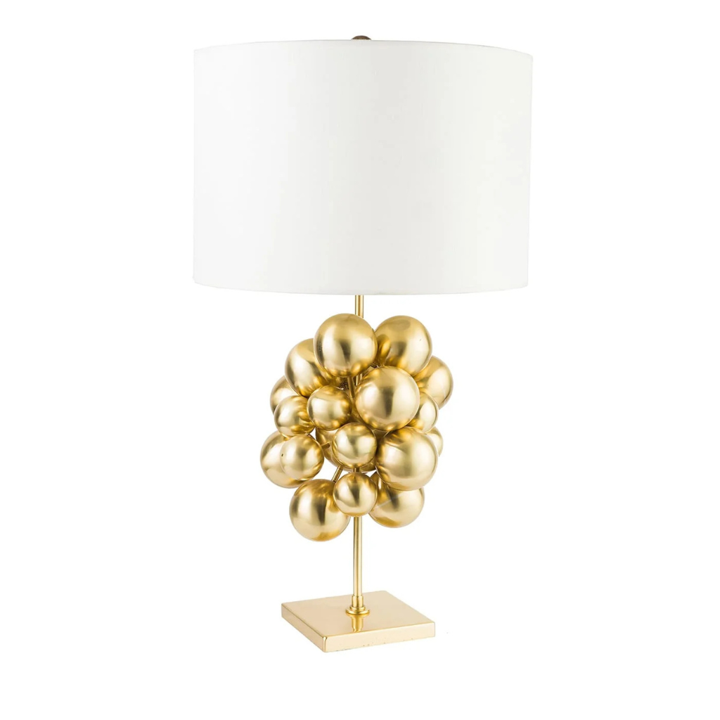 PLUTONE TABLE LAMP with cluster of polished gold spheres on a slim stem and square base topped with a wide ivory drum shade PLUTONE TABLE LAMP with cluster of polished gold spheres on a slim stem and square base topped with a wide ivory drum shade