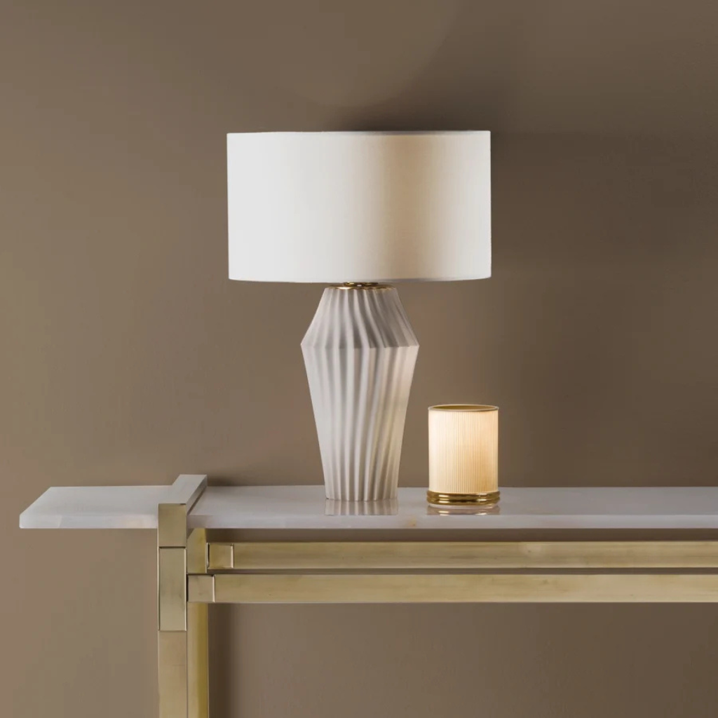 VERTIGO TABLE LAMP MATT WHITE with geometric diagonal ribbed faceted base and white drum shade on gold console, made in Italy VERTIGO TABLE LAMP MATT WHITE with geometric diagonal ribbed faceted base and white drum shade on gold console, made in Italy